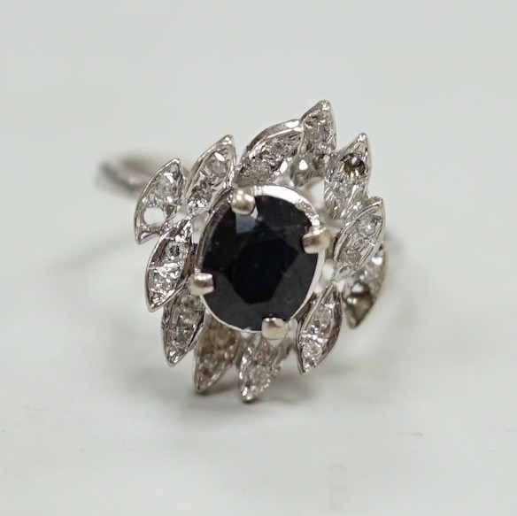 A modern 750 white metal, sapphire and diamond cluster set dress ring (two diamonds missing), size N, gross weight 5.2 grams.